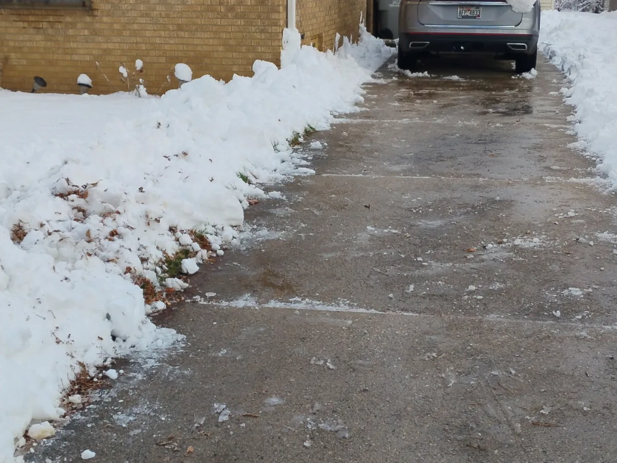Shoveled concrete sidewalk with snow banked on both sides